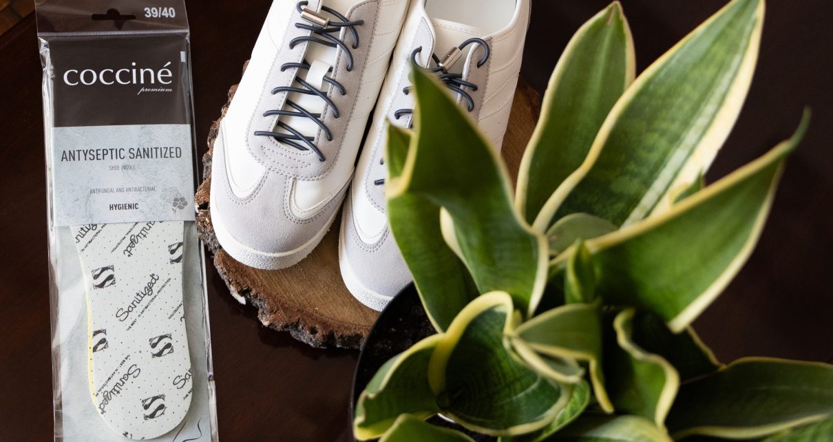Wkładki antybakteryjne Coccine obok białych sneakersów