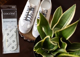 Wkładki antybakteryjne Coccine obok białych sneakersów